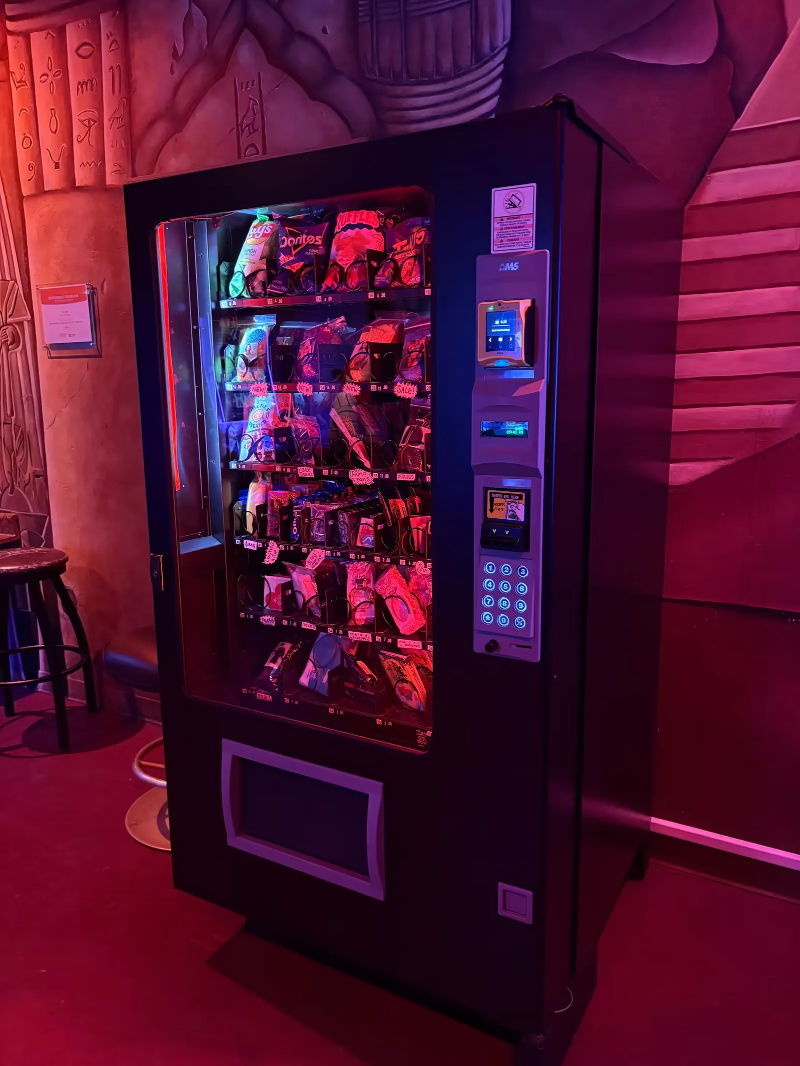 Boudoir Boxes machine against a painted mural wall inside a club