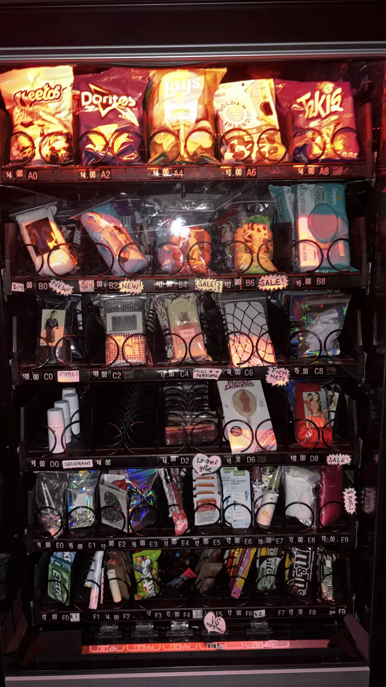 A fully restocked Boudoir Boxes machine with snacks on top and outfits, essentials and accessories below