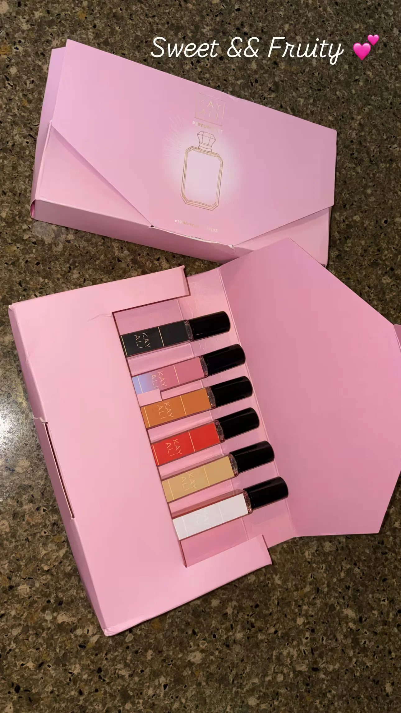 A pink box of perfume rollerballs ready for restocking